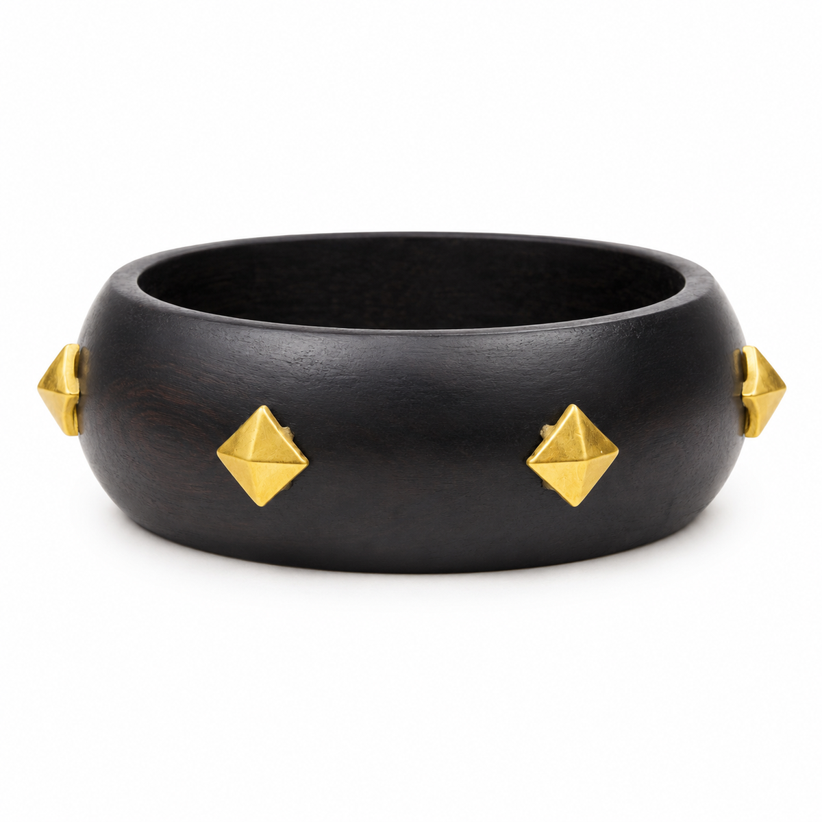 A wide black wooden bangle bracelet decorated with four gold pyramid-shaped metal studs, shown against a plain white background.