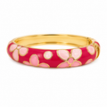 A gold-plated bangle bracelet featuring a vibrant magenta-pink floral enamel pattern with light pink inlay details, set against a clean white background.