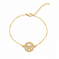 A delicate gold chain bracelet with a central circular motif featuring a butterfly design surrounded by small clear stones, set against a plain white background.