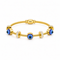 A gold cable-wrapped bracelet with evil eye charms and clear crystal accents, photographed on a clean white background.