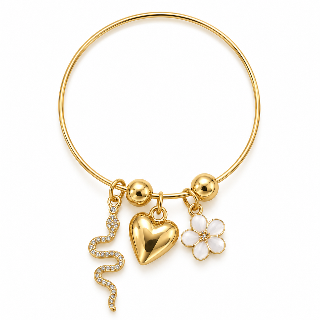 Gold bangle bracelet with dangling charms including a heart, a flower, a snake, and small gold beads, shown on a plain white background.