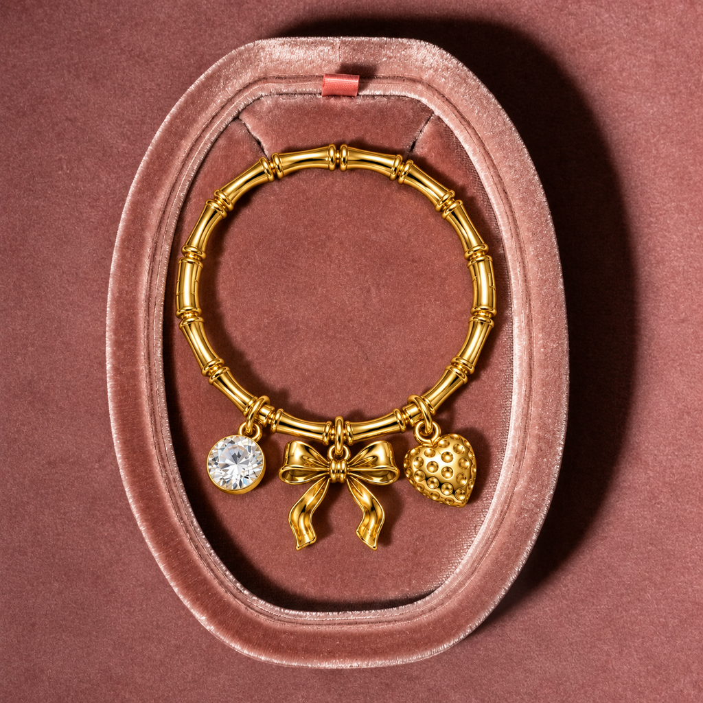 1. 18K PVD gold kada bracelet featuring bow, heart and sparkling CZ details