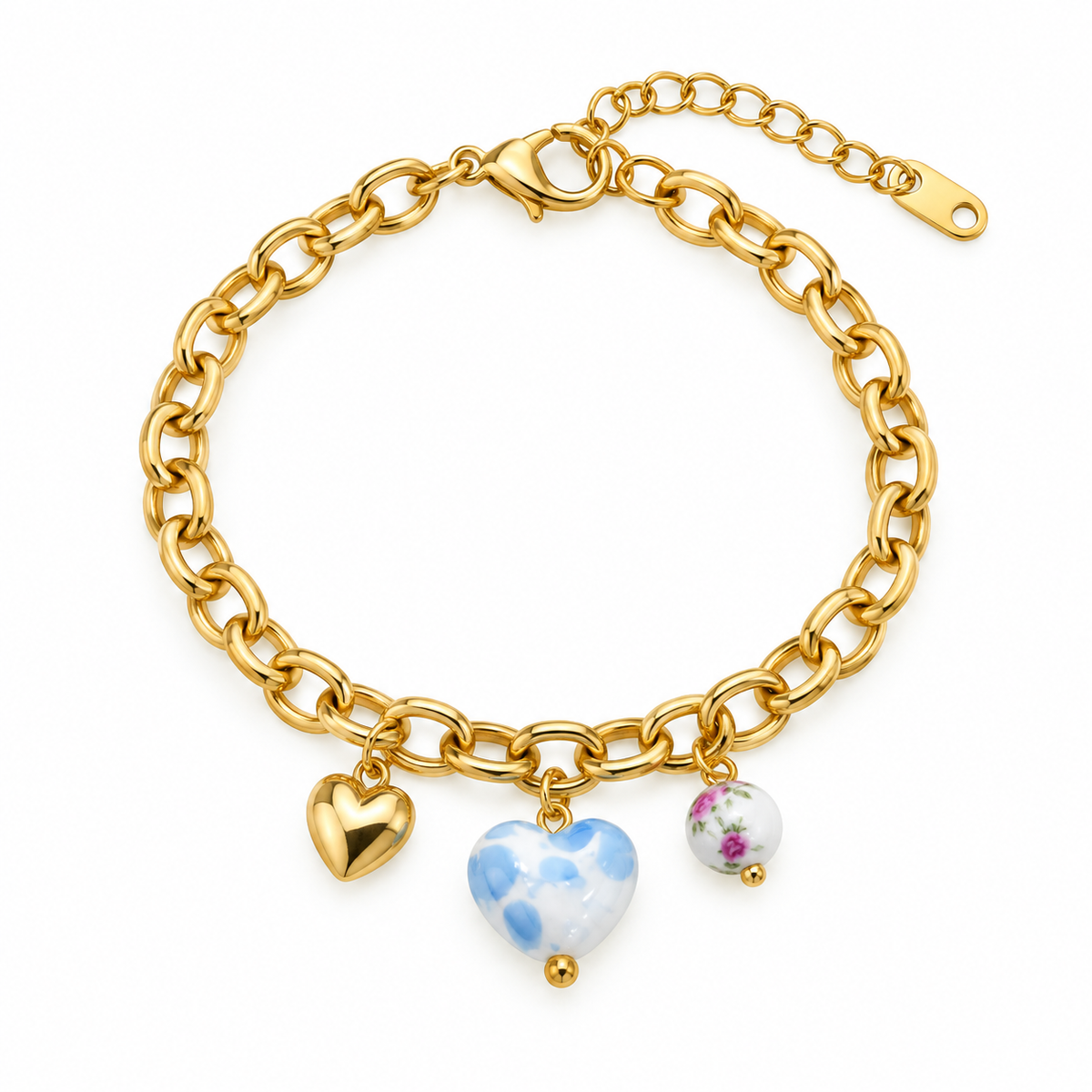 A gold chain charm bracelet featuring three heart-shaped charms: a plain gold heart, a blue and white marbled heart, and a small white heart with a floral print, set against a plain white background.