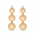 A pair of gold drop earrings featuring three stacked circular disc charms with a sunburst textured pattern in a pale peach-beige tone, each accented with a small white pearl stud at the top, shown against a plain white background.