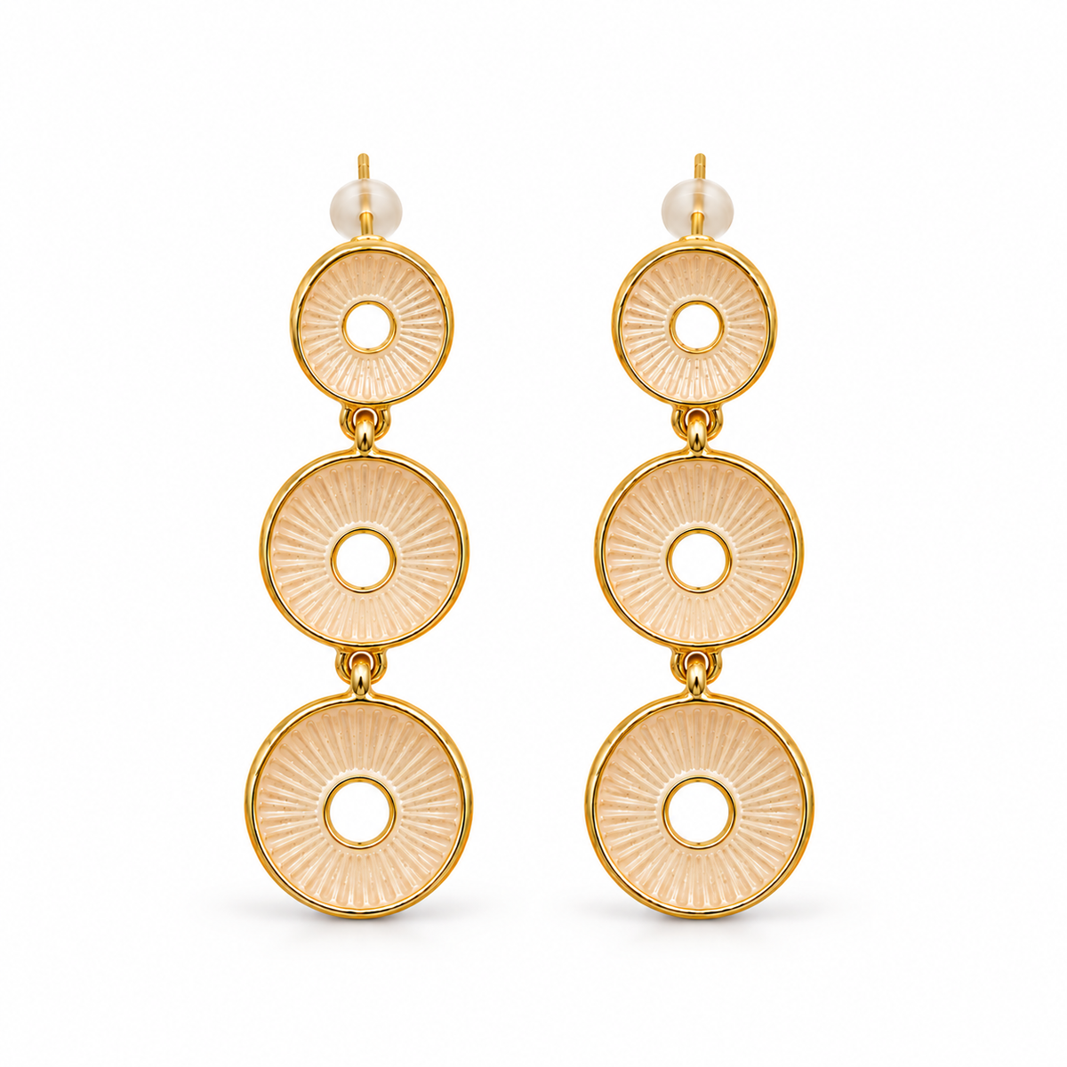 A pair of gold drop earrings featuring three stacked circular disc charms with a sunburst textured pattern in a pale peach-beige tone, each accented with a small white pearl stud at the top, shown against a plain white background.