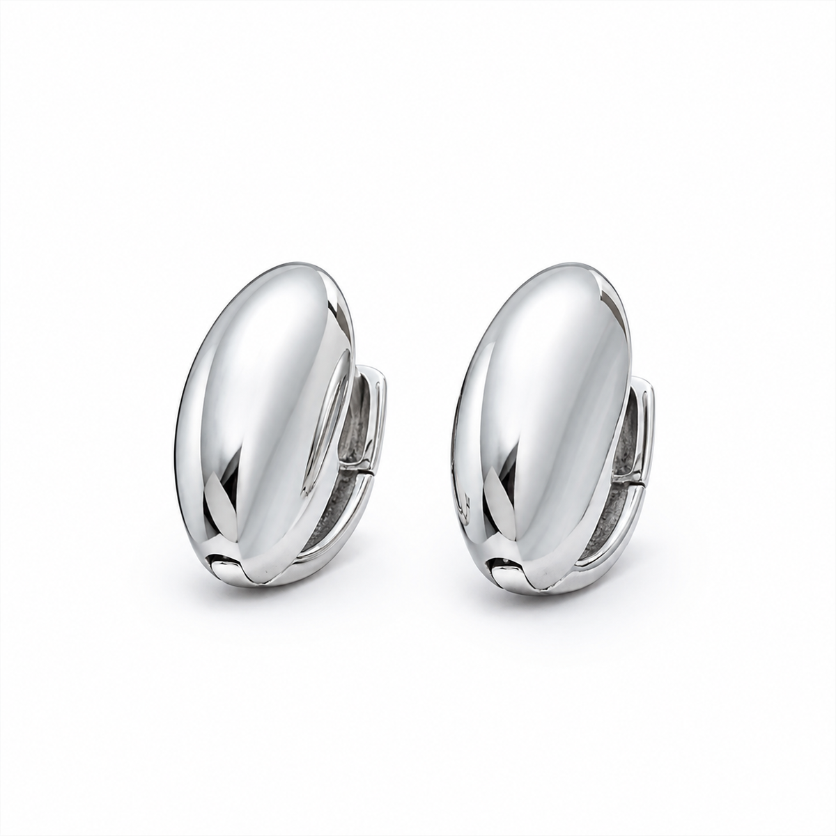 A pair of polished silver huggie hoop earrings with a smooth, reflective oval surface, shown on a clean white background.