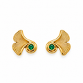 A pair of gold ginkgo leaf stud earrings, each featuring a textured gold leaf shape with a small round green gemstone at the center, set against a plain white background.