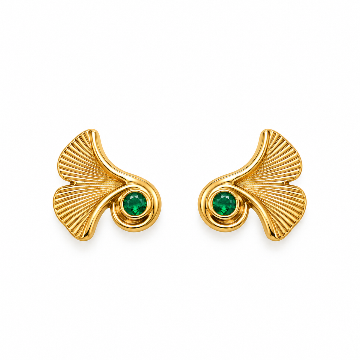 A pair of gold ginkgo leaf stud earrings, each featuring a textured gold leaf shape with a small round green gemstone at the center, set against a plain white background.