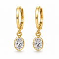 A pair of gold huggie hoop earrings with oval clear gemstones, shown on a clean white background.