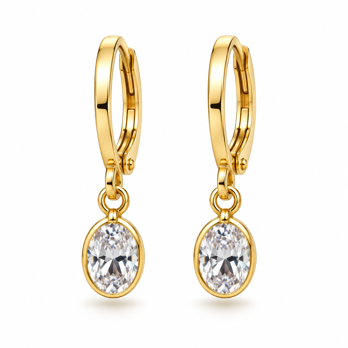 A pair of gold huggie hoop earrings with oval clear gemstones, shown on a clean white background.