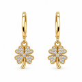 A pair of gold hoop earrings with dangling four-leaf clover charms paved with small clear stones, shown on a plain white background.