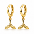 A pair of gold huggie hoop earrings with dangling mermaid tail charms, shown on a clean white background.