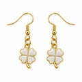 A pair of gold and white four-leaf clover dangle earrings on a solid white background.