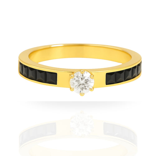 A yellow gold ring featuring a central round-cut clear gemstone in a prong setting, flanked by two rows of small black rectangular stones on the band, shown on a white background with a soft reflection.