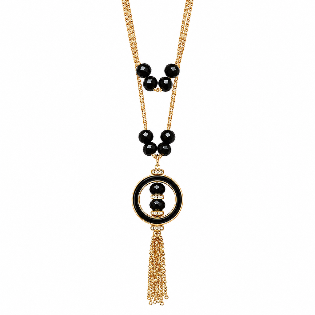 A gold-tone and black beaded necklace featuring a circular pendant with a central black bead, flanked by small gold beads, and finished with a dangling gold-tone tassel chain, shown on a plain white background.