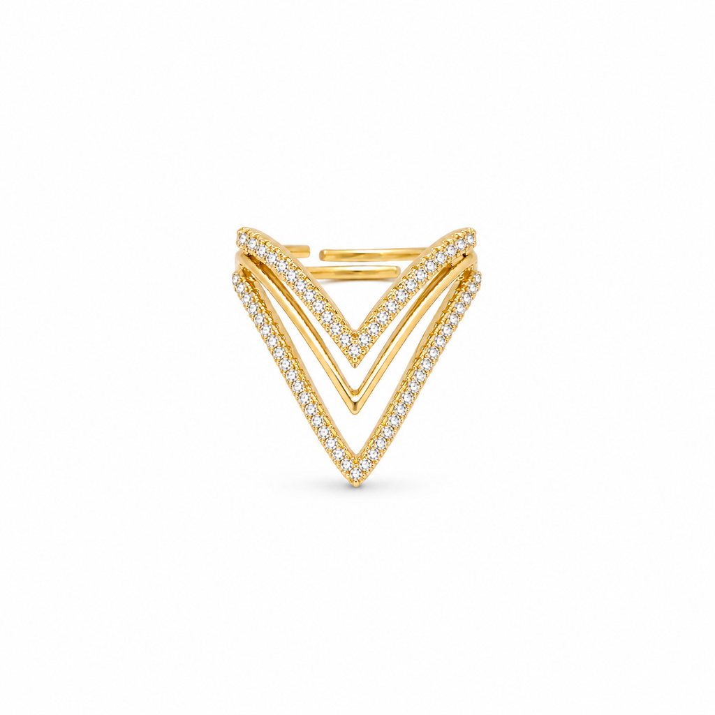 A gold chevron ring featuring multiple parallel V-shaped bands, with the outer bands paved with small clear stones, set against a plain white background.