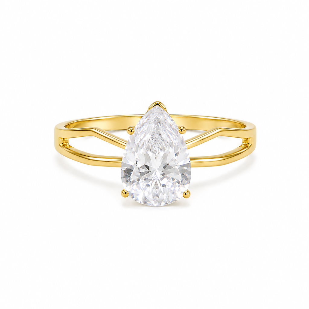 A pear-cut diamond ring set in a yellow gold band with a split shank design, shown on a clean white background.