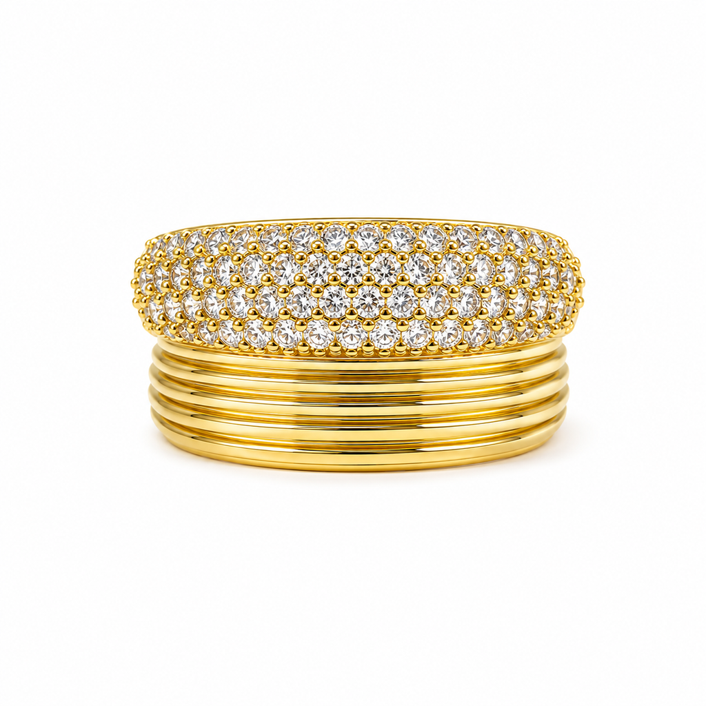 A gold ring featuring a top band set with multiple rows of round-cut clear gemstones and a lower band composed of five parallel grooves, shown on a plain white background.